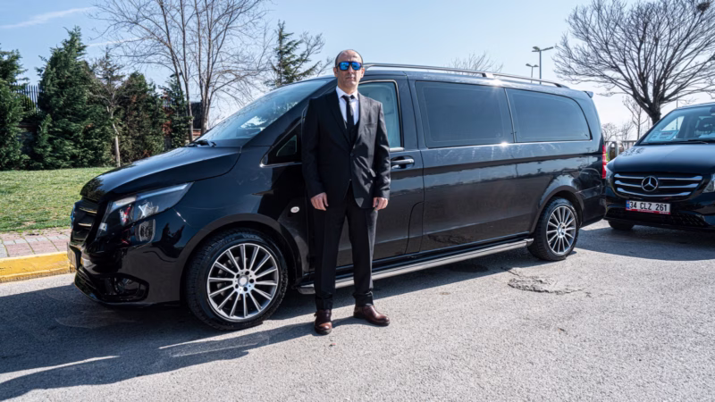 A driver with a black Mercedes minivan